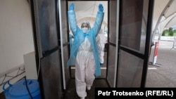 Коронавирусқа тест алатын орталықтағы дезинфекциялық өткелден өтіп бара жатқан медицина қызметкері. Алматы, 14 мамыр 2020 жыл.