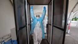 Медработник в защитной одежде в пункте тестирования.