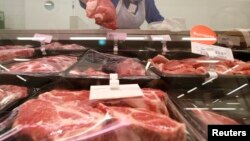 Russia -- A worker arranges slabs of meat for sale at a grocery store in Moscow August 7, 2014.
