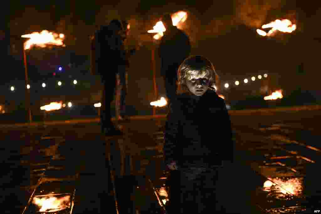 Kosovar Albanians stand in front of a bonfire as they take part in &quot;Night of the Fires&quot; ceremony in the village of Prekaz on March 7. (AFP/Armend Nimani)