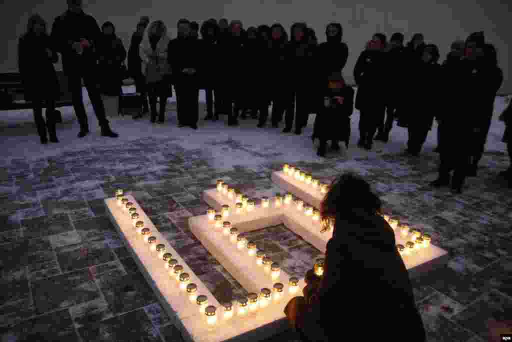 1991-nji ýylyň 13-nji ýanwarynda Litwada garaşsyzlyk protestleri sowetler tarapyndan basylyp ýatyrylanda pida bolanlary ýatlap, adamlar Wilnýusda, Bilim we ylym ministrliginiň binasynyň daş işiginde şem ýakýarlar.&nbsp; (epa)