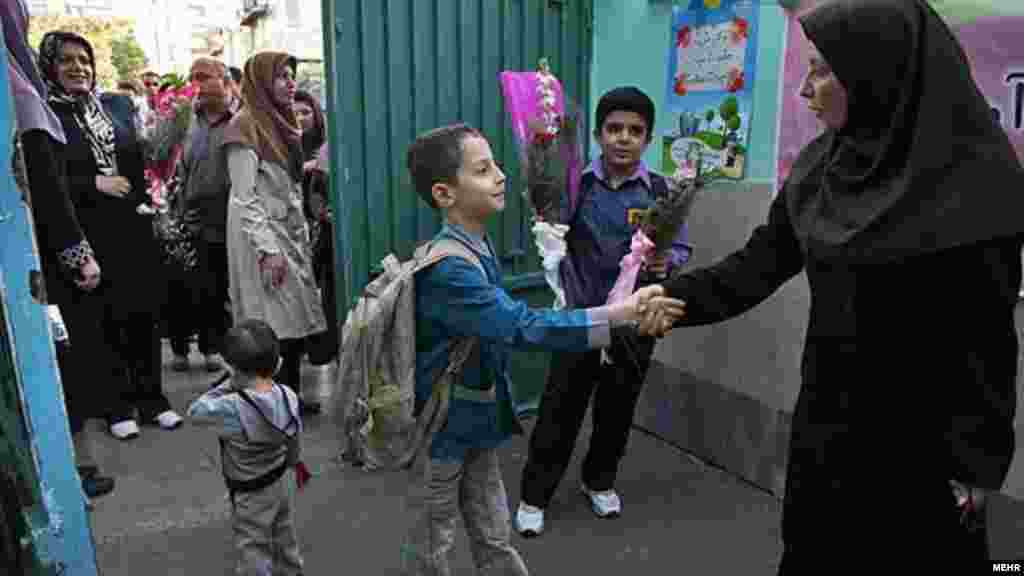 A pupil shakes hands with a teacher in Iran.