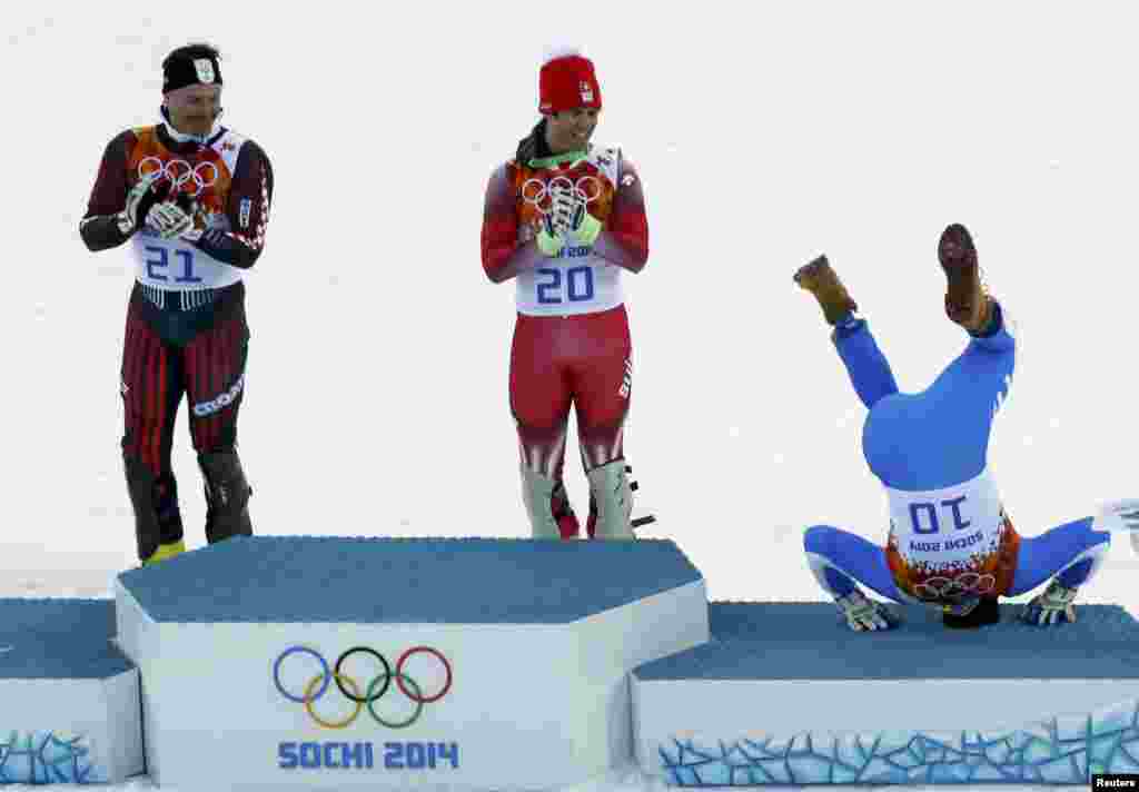 Bronze medalist Italy&#39;s Christof Innerhofer somersaults onto the podium as Swiss winner Sandro Viletta (center) and silver madalist Ivica Kostelic of Croatia laugh after the men&#39;s alpine skiing super combined event. (Reuters/Stefano Rellandini)