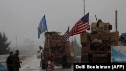 A line of U.S. military vehicles drive through a checkpoint of the Internal Security Forces in Manbij as they head to their base on the outskirts of the northern Syrian city, December 30, 2018. File photo