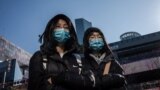 CHINA -- People wear protective masks as they walk outside a shopping mall in Beijing on January 23, 2020. 