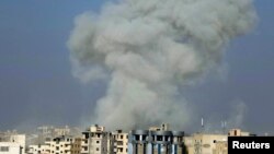 Smoke rises after what activists said was an air strike by Syrian government forces in Raqqa, eastern Syria, which is controlled by the militant group Islamic State, on November 19.