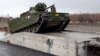 A Norwegian CV9030 armored infantry combat vehicle drives up a ramp and on to a train during thee NATO-led Trident Juncture exercises in Stjordal, Norway, on October 24.