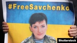 Плакат с изображением Надежды Савченко держит участник акции в ее поддержку. Харьков, 9 марта 2016 года. 