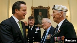 British Prime Minister David Cameron (left) meets Arctic Convoy veterans during a special medal presentation ceremony on Downing Street on March 19. 