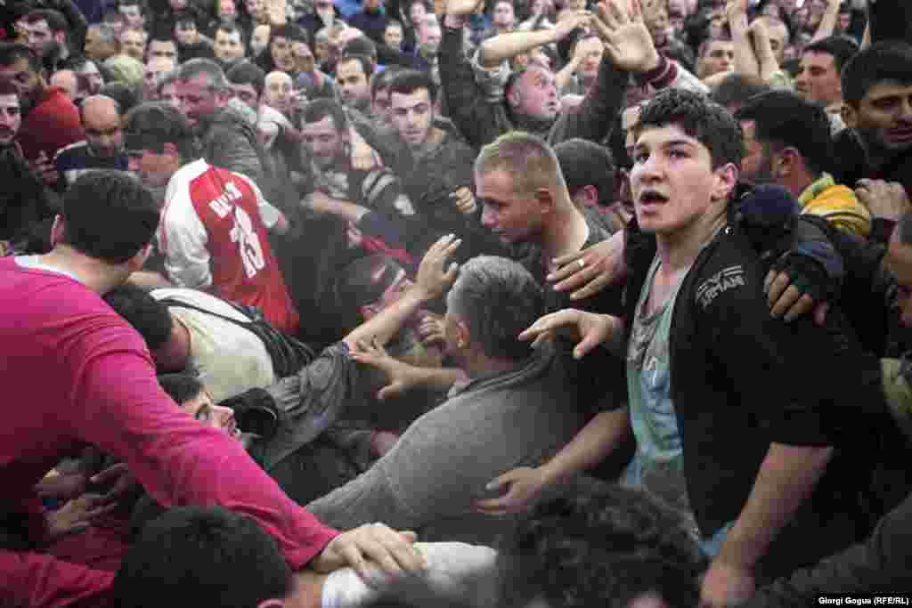 Dozens of players push as hard as they can, trying to move the ball toward their opponent&#39;s end of the village.