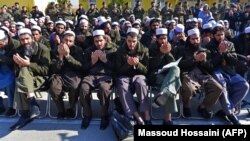 Released Taliban prisoners sit on chairs and pray during a ceremony in Pul-e Charkhi jail on January 4. Observers wonder how many of them will simply rejoin the fight?