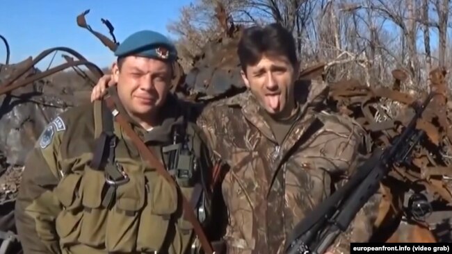 Сербський бойовик Деян Берич передає «привіт» уряду Сербії (справа)