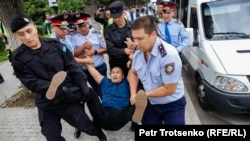 Полиция қызметкерлері қала тұрғыны Арман Абдуллахановты көлікке күштеп салғалы жатыр. Алматы, 10 маусым 2019 жыл.
