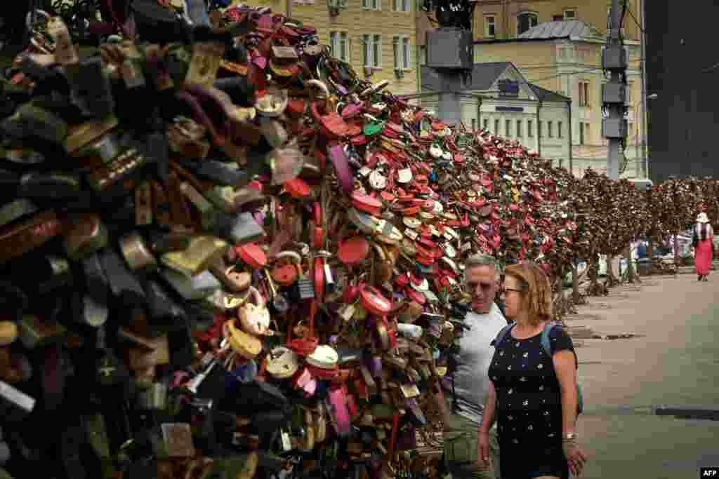 A couple looks at padlocks hanging on tree-shaped metal sculptures in central Moscow. (AFP/Kirill Kudryavtsev)