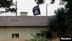 Flamuri i militantëve të Shtetit Islamik shihet në Jarablus, fotografuar nga ana turke e kufirit 