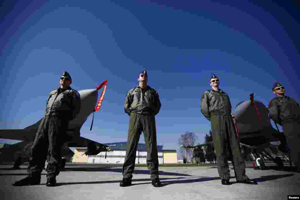 Polish pilots stand in front of F-16 fighter jets during a visit by the country's President Bronislaw Komorowski to the Lask airbase on March 11. (Reuters/Kacper Pempel)