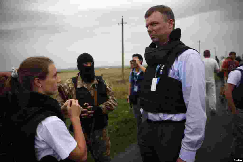 OSCE monitors speak with a pro-Russian separatist about gaining access to a crash site near Hrabove on July 18.&nbsp;