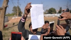 Journalists take images of the court verdict against the accused suspects outside the central jail in Haripur district on February 7, 2018.