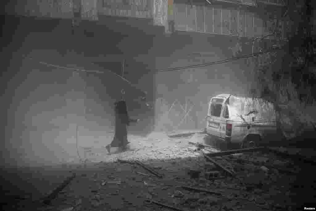 Howa zarbasyndan gaçan çagaly aýal, &nbsp;Douma, Siriýa. (Reuters/Bassam Khabieh)