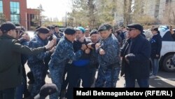 Астанада полиция арнайы жасағы наразылық митингісіне шыққандарды ұстап әкетіп барады. 10 мамыр 2018 жыл.