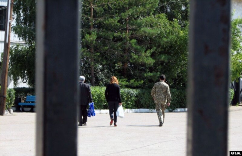 Джамиля Джакишева в сопровождении охранника идет по внутреннему двору тюрьмы КНБ. Астана, 31 июля 2009 года.