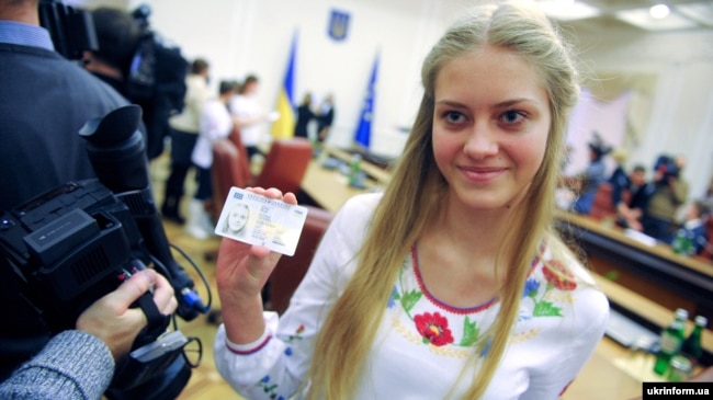 Дівчина показує свій паспорт громадянина України у формі ID-картки