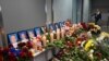 An employee walks in background of a makeshift memorial set up for the victims of the Ukraine International Airlines Boeing 737-800 that crashed near the Iranian capital Teheran, at the Boryspil airport outside Kiev, on January 11, 2020.