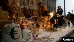 Residents are reflected in a shop window with logos of the euro, U.S. dollar, and ruble on bags inside, in central Moscow, on December 10.