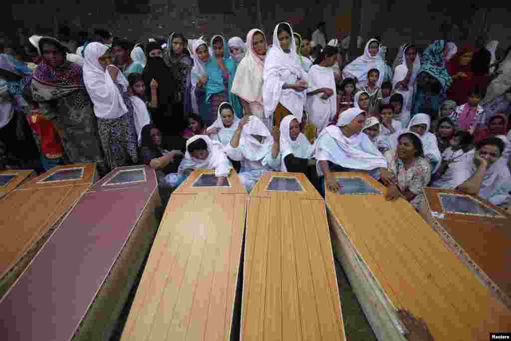 Christian women mourn next to coffins of their relatives, who were killed in a Peshawar suicide attack. (Reuters/Fayaz Aziz)