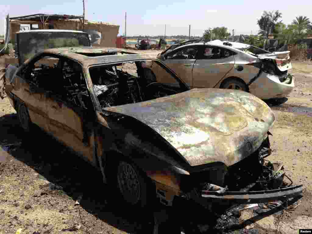 Damaged vehicles at the site of a car bomb attack in Ramadi.