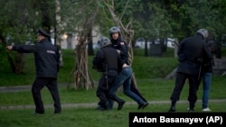 Russian police officers detain demonstrators protesting plans to construct a church in a park in Yekaterinburg. 