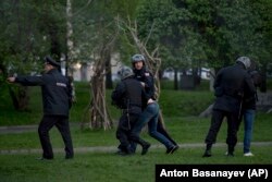 Police officers detain demonstrators protesting plans to construct a cathedral in a park in Yekaterinburg on May 14, 2019.