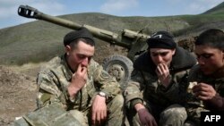 Nagorno-Karabakh -- Soldiers of the defense army of Nagorny Karabakh have lunch near a gun at their field position outside the village of Mataghis, some 70km north of Karabakh's capital Stepanakert, April 6, 2016