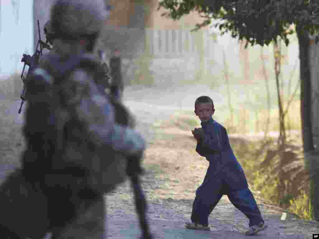 A young boy reacts as a German Army soldier patrols outside Kunduz, Afghanistan, on September 20. (Photo taken by Anja Niedringhaus for AP)