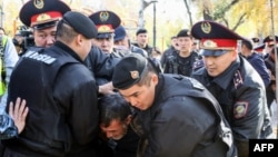 Полицейские задерживают участника протеста в Алматы. 26 октября 2019 года.