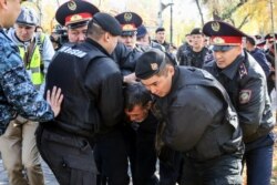 Полицейские задерживают участника протеста в Алматы. 26 октября 2019 года.