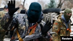 Славянск қаласындағы милиция ғимаратын басып алған қарулы топ мүшелерінің бірі. 12 сәуір 2014 жыл.
