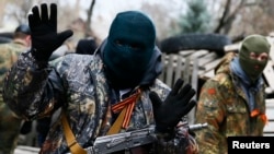 Славянск қаласының полиция ғимаратын басып алған қарулы топ мүшелерінің бірі. 12 сәуір 2014 жыл. 