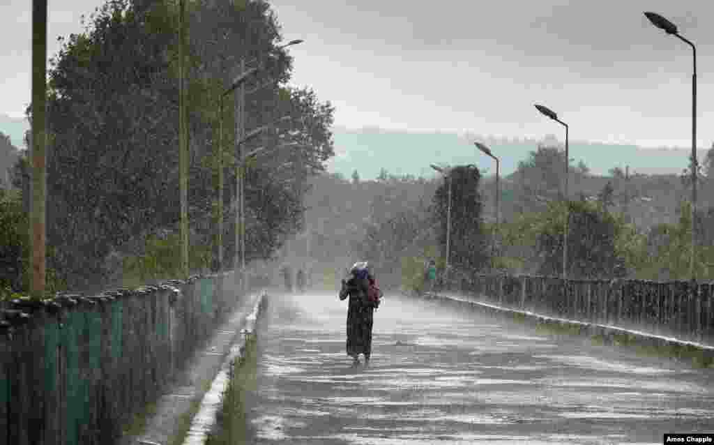 A resident of Gali walks the bridge which separates the rest of Georgia from Abkhazia. The de facto border is manned by Russian security officers.