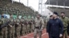 Глава Чечни Рамзан Кадыров (на переднем плане) на стадионе проходит мимо вооруженных людей, которых он назвал «боевой пехотой Путина». Грозный, 28 декабря 2014 года.