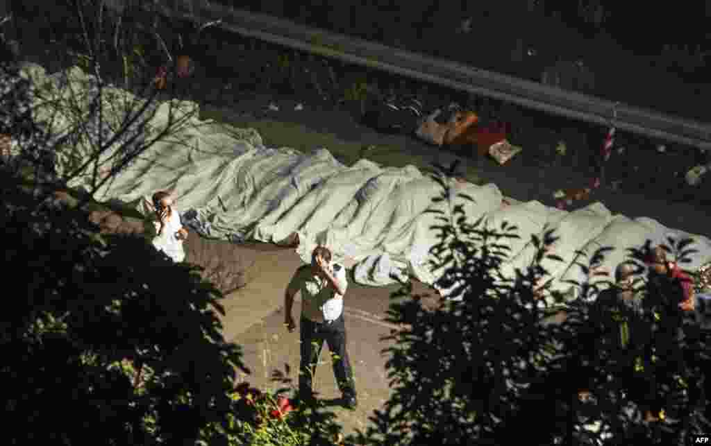 Bodies of victims of a bus crash are lined up on the road between Monteforte Irpino and Baiano, Italy. At least 36 people were killed after a coach carrying pilgrims plunged off a motorway in southern Italy. (AFP)