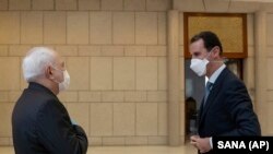 Голова МЗС Ірані Джавад Заріф (ліворуч) та президент Сирії Башар аль-Асад (праворуч) під час зустрічі в Дамаску, 20 квітня 2020 року