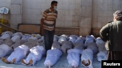 Activists inspect the bodies of people they say were killed by nerve gas in the Ghouta region, in the Duma neighborhood of Damascus, on August 21.