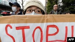 Members of various civic groups hold placards in Tokyo denouncing the use of nuclear power during a rally in front of the headquarters of the Tokyo Electric Power Company.