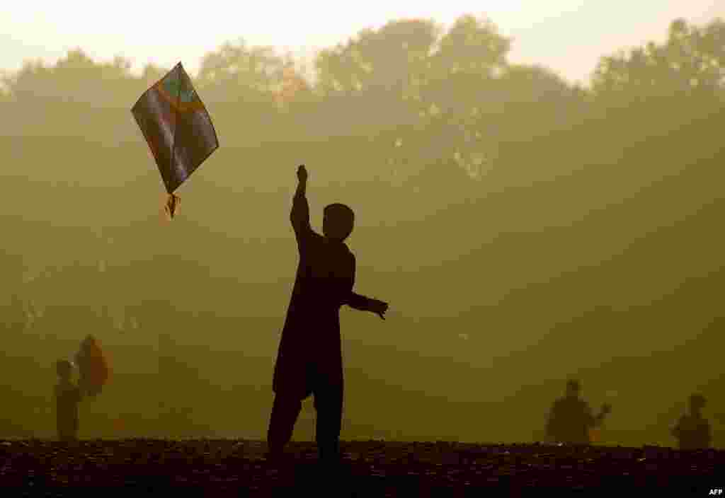 An Afghan child plays with a kite as sun sets on the outskirts of Herat. (AFP/Aref Karimi)