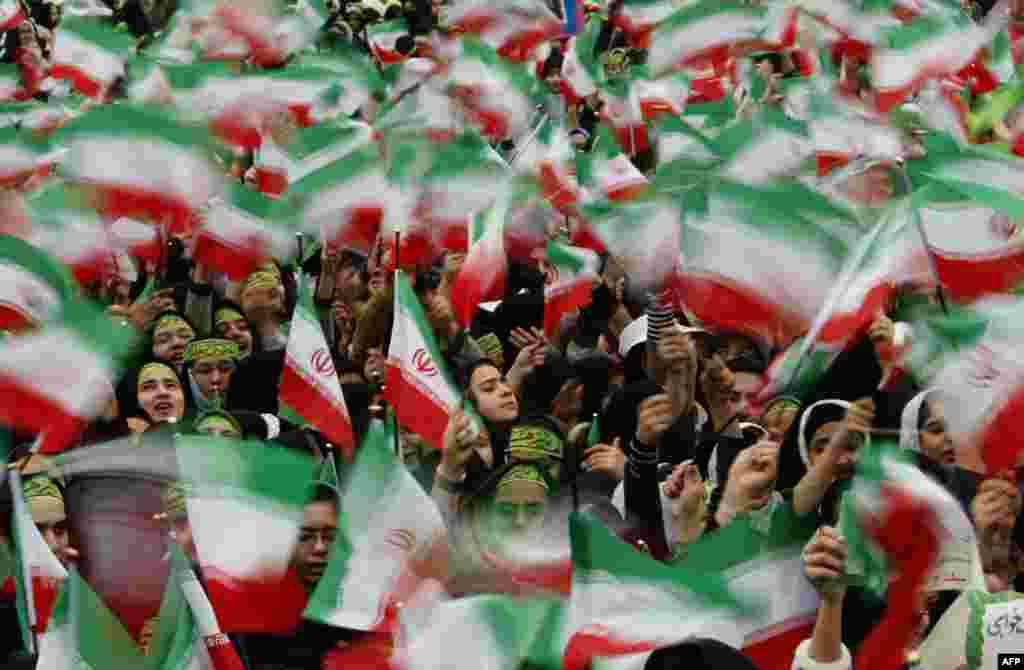 Iranian schoolgirls wave Iranian flags during a rally to mark the 30th anniversary of the Islamic revolution at Azadi (Freedom) square in Tehran on February 10, 2009. Tens of thousands of Iranians chanting anti-US slogans took to streets of Tehran for a mass rally marking 30 years since the Islamic revolution toppled the U.S.-backed shah. (AFP/Behrouz Mehri) 