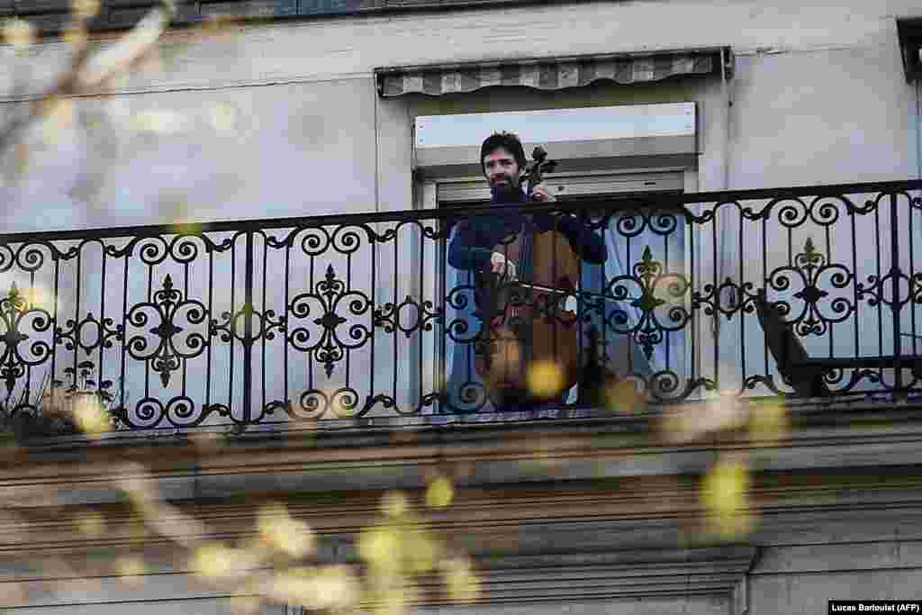 Віолончеліст Каміло Перальта грає на своєму балконі в Парижі під час карантину, спрямованого на стримування поширення COVID-19