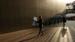 Një grua me një balonë dhe një flamur të BE-së duke ecur jashtë ndërtesës së Parlamentit Evropian në Bruksel. Fotografi ilustruese nga arkivi.