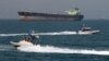 Iran -- Revolutionary Guards drive speedboats in front of an oil tanker during a ceremony to commemorate the 24th anniversary of the downing of Iran Air flight 655 by the US navy, at the port of Bandar Abbas, 02Jul2012