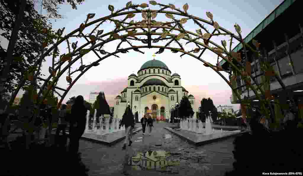 People walk in front of the Church of Saint Sava in Belgrade, Serbia. (epa-EFE/Koca Sulejmanovic)